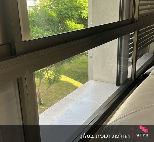 חלון זכוכית עם נוף לעצים ובניינים